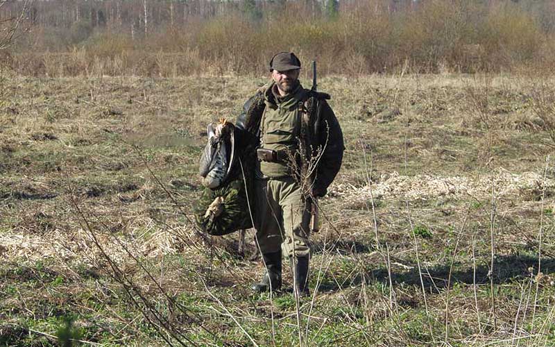 охотник на весеннем поле со снаряжением